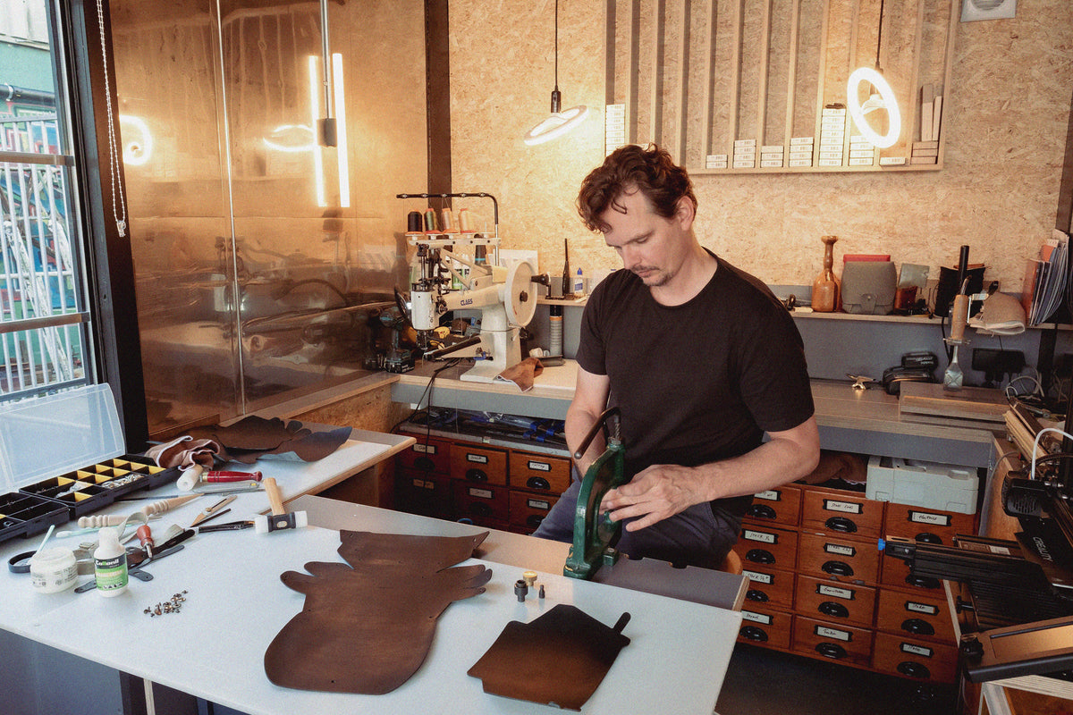 Johannes in his Nitmoi Atelier making handmade leather key holder with solid brass hardware from the Netherlands
